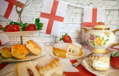 St Georges Günü öğleden sonra çay, klasik geleneksel çörekler çilekler ve kremalı Victoria pastası İngiltere bayrağı. 