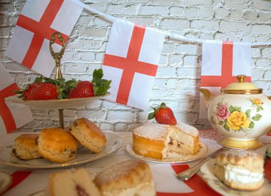 St Georges Günü öğleden sonra çay, klasik geleneksel çörekler çilekler ve kremalı Victoria pastası İngiltere bayrağı. 