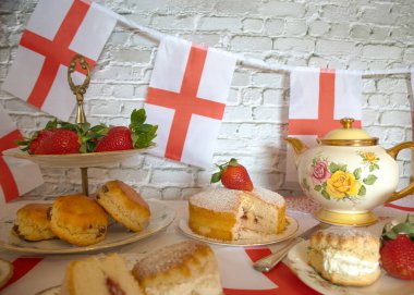 St Georges Günü öğleden sonra çay, klasik geleneksel çörekler çilekler ve kremalı Victoria pastası İngiltere bayrağı. 