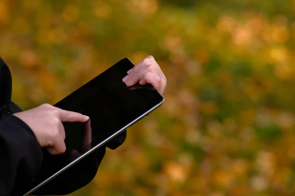 Tabletli bir çocuk internetten kitap öğreniyor. Çocuğun elleri tablet, dokunmatik kâğıt, tablet üzerinde parmak izi tutuyor. Güzel bir arkaplan üzerinde tabletle çalışıyor. Yüksek kalite fotoğraf