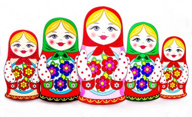 Gülen yüzü, pembe yanakları, çizim çiçekleri ve beyaz arka planda yaprakları olan geleneksel Rus matruşka bebeklerinin inanılmaz kompozisyonu