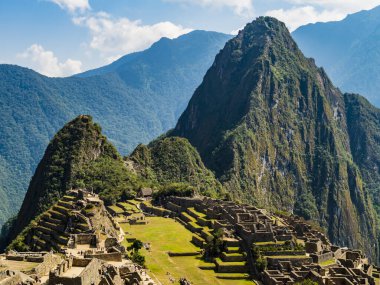 Panoramic view of the lost inca city Machu Picchu, with ruins of the old town, agricultural terraced fields and Huayna Picchu peak in background, Sacred valley of Incas, Cusco region, Peru