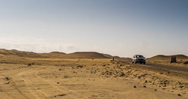 Paracas Ulusal Rezerv bölgesinden geçen turist arabası, Peru 'da manzaralı bir toprak yoldan geçiyor. 