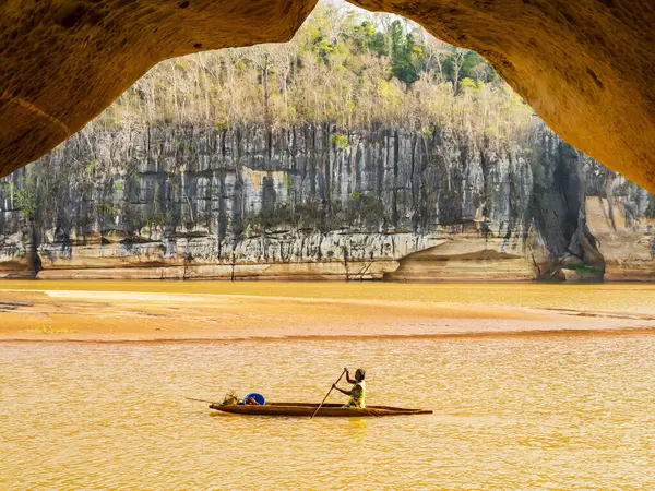 Geleneksel kanosuyla Manambolo nehrinde kürek çeken, arka planda muhteşem taş oluşumları olan yerli bir kadın, Tsingy de Bemaraha Katı Doğa Koruma Alanı, Madagaskar 
