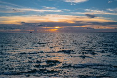 Gün batımlı ya da gün doğumlu deniz sahili. Gün batımı denizi üzerindeki bulutlar. Tropik plajda gün batımı. Akşam denizinin doğa gün batımı manzarası