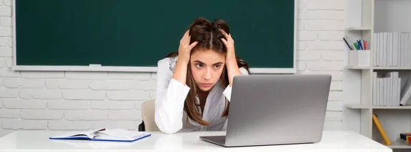 슬프고 귀여운 여학생 학교에서 컴퓨터를 사용하고 있습니다 온라인으로 학교에서 배우기 — 스톡 사진