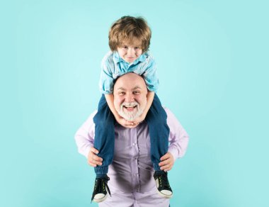 Stüdyoda mavi bir yüze sahip büyükbaba ve oğul sırtına biniyorlar. Büyükbaba ve komik yüzlü tatlı çocuk.