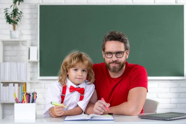 Okuldaki ilk günüm. Sınıfta ders çalışan şirin bir çocuk. Sevimli ilkokul çocuğu.