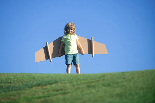空の青の背景にパイロットを果たしている子供の男の子 夢を見てる おもちゃのジェットパックで遊ぶ子供 子供パイロットは公園で楽しんでいます 子供のリーダーのスタートアップコンセプト — ストック写真