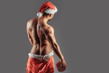 Christmas sexy man with gift. New year strip and gifts for adults. Muscle man torso with sexy buttocks butt. Santa with muscular body back