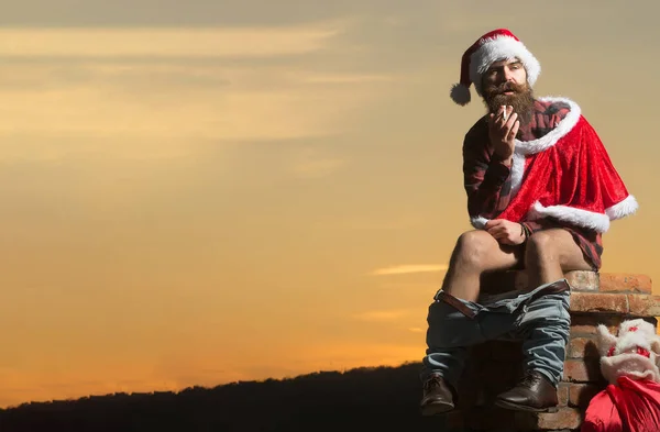 Bad santa concept. Bad Santa Claus sit naked on chimney. Bad brutal man celebrate winter christmas holidays. Santa sitting on the chimney of a bad persons house