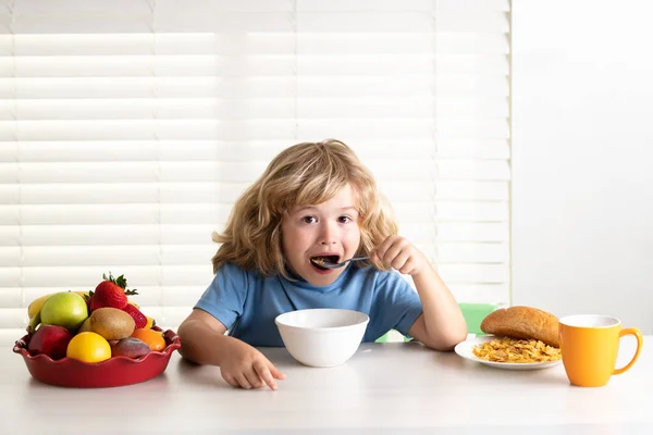 Kid bot eating meal. Healthy nutrition for children. Child enjoy eating for breakfast or dinner with appetite. Hungry child eat tasty fruits and vegetables