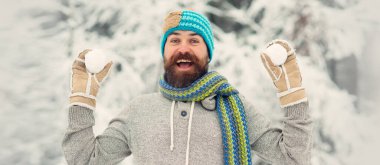 Adam kartopu atıyor. Kar oyunları. Adam kartopu ve karla oynuyor. Kardaki mutlu adam kartopu yapar. Soğuk kış havasında kış aktiviteleri. Sakallı adam karlı parkta gülüyor.