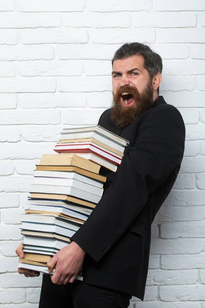Funny teacher or professor with book stack. Thinking serious mature teacher. Mature professor, middle aged teacher, bearded fun man. Exam in college or university. Falling books concept