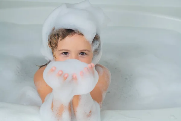 Funny child playing with foam in bath