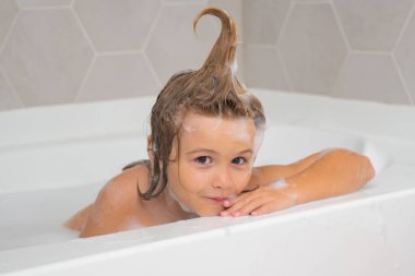 Çocuklar banyo yapar. Çocuk köpükle banyo yapıyor. Banyoda banyo yapan komik çocuk suratı.