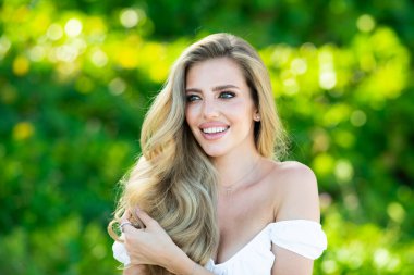 Bahar Parkı 'nda şehvetli bakışları olan seksi bir kadın. Dışarıda güzel bir kadın modelin güzel portresi var. Güzel yüzlü bir kadın, yeşil doğada doğal bir teni var. Güzel kız bahar parkında dinleniyor.