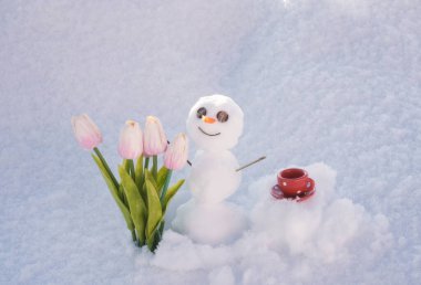 Merhaba ilkbahar, güle güle kış. Kahve fincanlı kardan adam. Çiçekli kardan adam