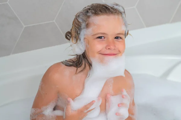 Cute child washing and bathing in a bath with foam. Funny kid face bathed in the bath
