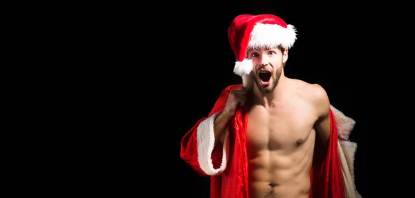 クリスマスのセクシー男 サンタの帽子の興奮した男性 新年のストリップと大人のための贈り物 マッスルはクリスマスに男を驚かせた 筋肉質の体でサンタ セクシーサンタクラス男オン黒背景 — ストック写真