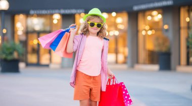 Alışveriş torbalı çocuk. Moda ve satış. İyi alışverişler