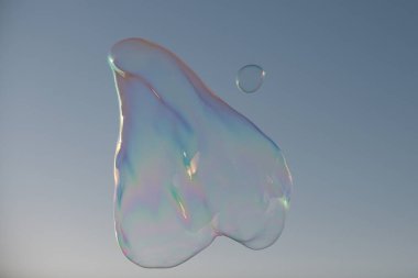 Büyük sabun köpüğü. Mavi gökyüzünde renkli sabun köpüğü