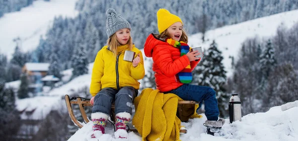 子供の男の子と女の子は冬に眠っていた 冬には雪のスライドに乗っている子供たち 息子と娘はそりに乗るのを楽しむ — ストック写真