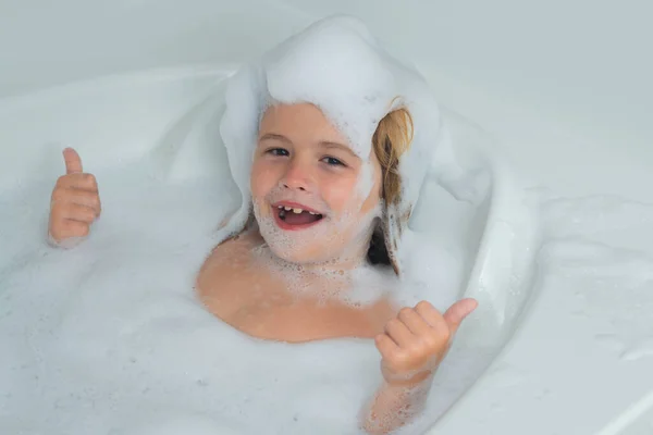 孩子们脸上都是泡沫洗澡时带着泡泡的孩子可爱的孩子洗澡了 躺在一个用肥皂和洗发水泡的白色浴缸里 — 图库照片