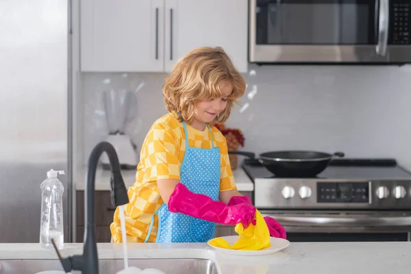 Child cleaning dishware kitchen sink sponge washing dish. Kid housekeeper. Child washing and wiping dishes in kitchen. Kid cleaning to help parents with housework routine. Housekeeping children