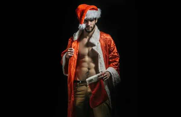 圣诞节性感男人 戴着桑塔帽的壮汉 新年脱衣舞和大人的礼物圣诞节的时候肌肉是快乐的 圣诞老人肌肉发达 黑色背景的性感年轻圣诞老人 — 图库照片