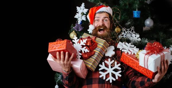 令人惊讶的人与礼物 嬉皮士 戴着桑塔帽 穿着冬季毛衣 玩得很开心 带着礼物开心的男人 — 图库照片