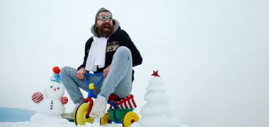 Bisikletli çılgın kış adamı. Kışın arka planda kardan adam. Kış bayrağı için kardan adam. Dışarıda bisiklete binen komik baba.