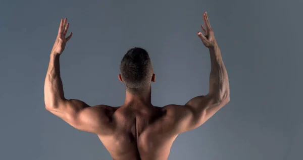 健康模式 一个身强体壮 身体赤裸的家伙 肌肉发达的男人又靠在灰色的背带上 强壮的男模 — 图库照片