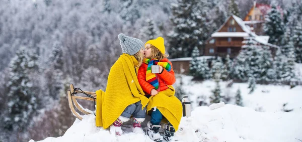 子供のロマンチックな冬 そりの抱擁とキスに座っている小さなカップル 雪の中で子供の友達キス 子供は物語が好き — ストック写真