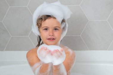 Çocuk şampuanı. Çocuk köpüklü bir banyoda. Çocuklar banyo ve hijyen prosedürleri.