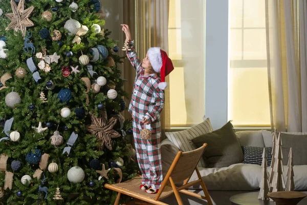 クリスマスツリーの近くのサンタの帽子で幸せな面白い子供 クリスマスと新年のコンセプト — ストック写真