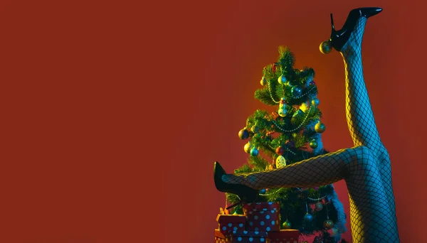 Sexy Pernas Femininas Perto Árvore Natal Fundo Isolado Vermelho Natal — Fotografia de Stock