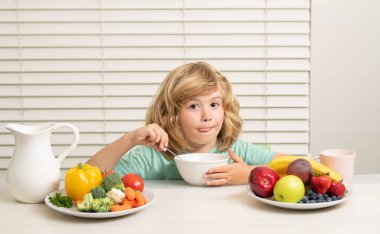 Müsli gevreğiyle sabah atıştırması. Açlık, iştah konsepti. Çocuk organik sağlıklı yiyecekler yiyor. Vitaminli sağlıklı sebzeler. Gerçek çocuk beslenme konsepti