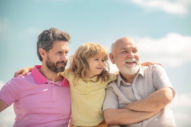 Üç nesildir birlikte, gülümseyen çocuk, baba ve büyükbaba portresi. Büyükbaba ve oğul çocuk portresi. Babalar Günü. Farklı yaşlardaki erkekler.