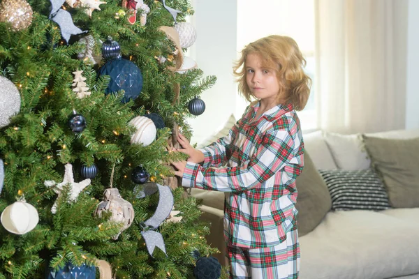 圣诞快乐 圣诞节和快乐的假期在家里 快乐可爱的小男孩装饰着圣诞树 孩子们带着圣诞球和玩具在房间里的树上 — 图库照片