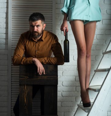 Yüksek topuklu giyen baştan çıkarıcı bir kadın. Şarabı olan kadın. Seksi erkek ve kadın bacakları. Seksi çift şarap tadıyor.