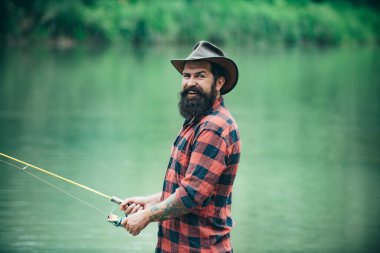 Elinde olta olan adam, nehir suyundaki balıkçılar. Yaz balıkçılık hobisi