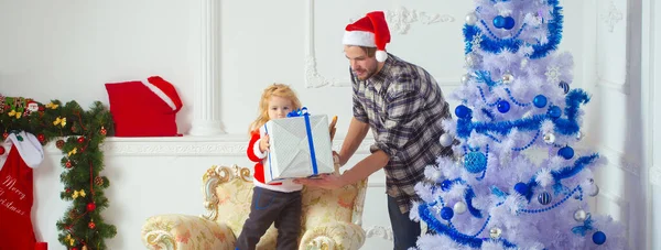身穿圣诞老人服装的弟弟和小孩打开了圣诞节的惊喜礼物 家庭寒假和人的概念 — 图库照片