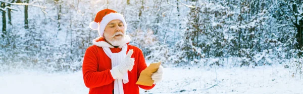 圣诞老人给圣塔克洛斯读圣诞信 圣诞老人读信给圣诞老人关于雪原森林 — 图库照片