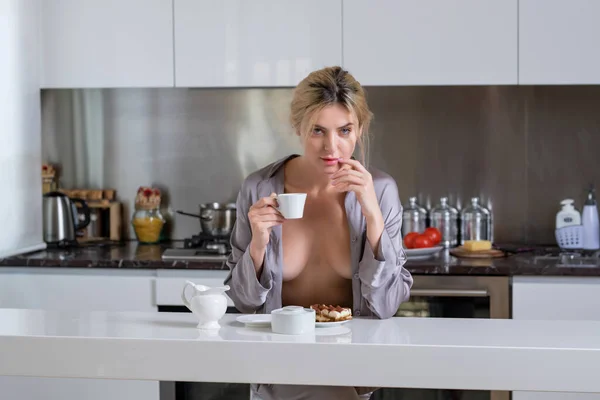 無修正パジャマの官能的な女の子はコーヒーをお楽しみください モダンなキッチンで朝のコーヒーとセクシーな女性 コーヒーを飲みながらセクシーなヌードトップレスの女性 セクシーモデルカバー大胸ともにPajama — ストック写真