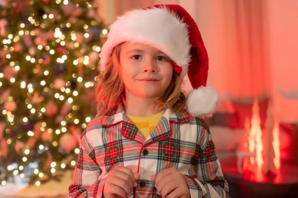 8岁的男孩 穿着圣诞睡衣 在家里靠近圣诞树的地方享受寒假 — 图库照片