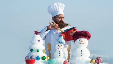 Kış aşçısı. Kar adam aşçı aşçı arka planda kar arka planı. Kardan adamla Noel afişi. Kardan adamla birlikte kış tebrik kartı. Kış arkaplanı