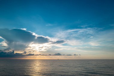 Denizde gün batımı. Sahilde gün batımı. Tropikal sahilde gün doğumu denizi. Güzel bir sahil manzarası. Denizde güzel bir gün batımı. Gökyüzünde gün batımı arkaplanı renkli bulutlarla