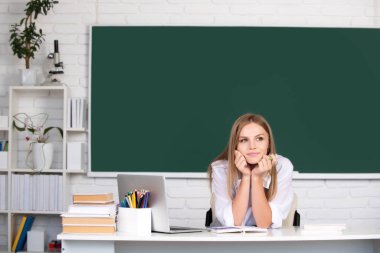 Sınıfta okuyan genç bir üniversite öğrencisinin portresi. Tahta altyapısı var. Okula geri dön.