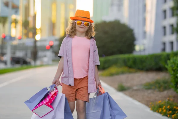 Kid with shopping bags. Fashion and sale